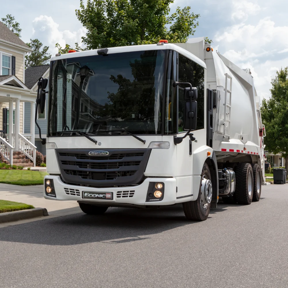 Freightliner refuse truck in front of residential homes